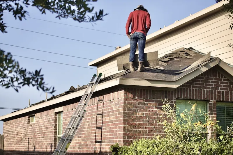 Professional roofer working on a residential roof in West